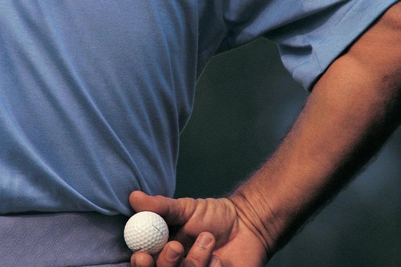 Golfbal en handschoen vlak voor de afslag