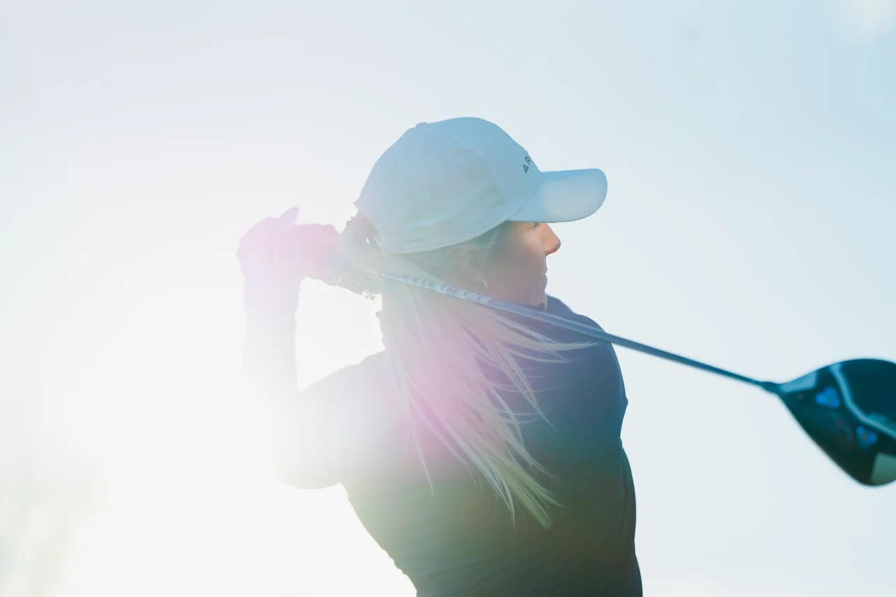 Golfster in haar follow-through tijdens een slag